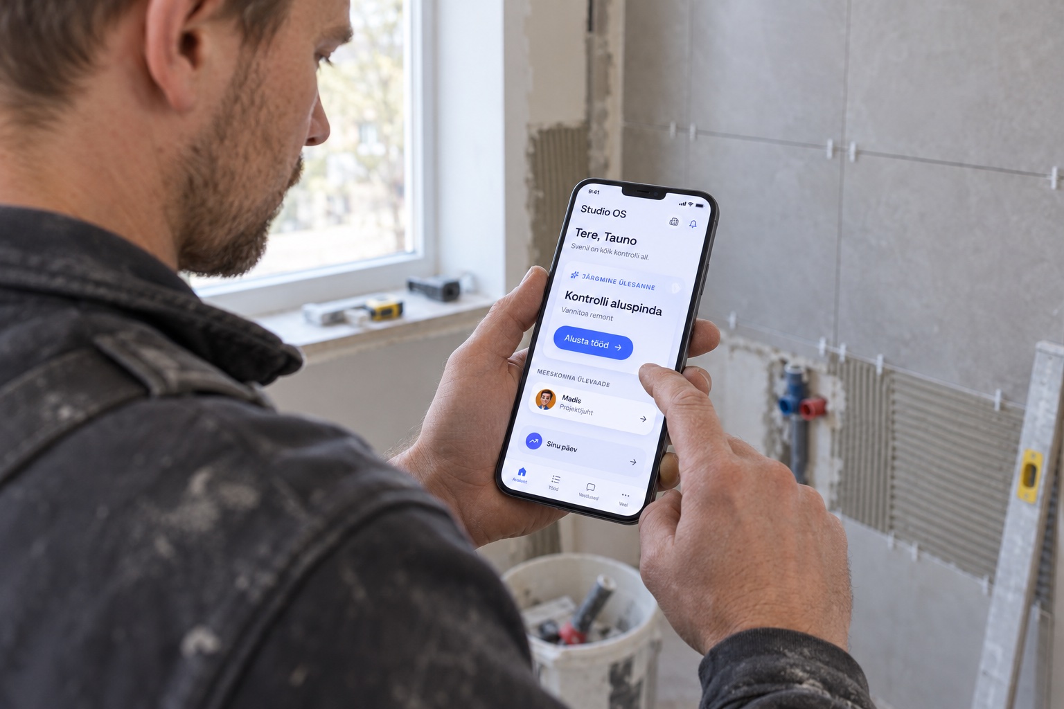 Ehitusmees kasutab objektil telefonis Studiot, et vaadata järgmist tööülesannet.